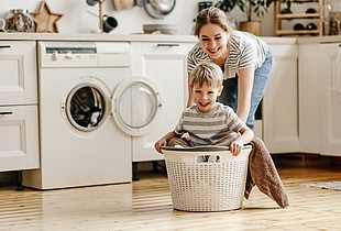 Mutter und Sohn spielen in der Küche beim Waschen.