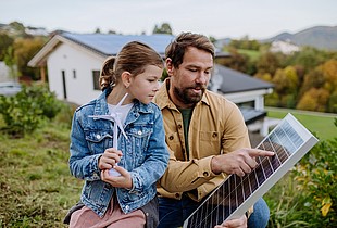 Vater und Tochter an einer Photovoltaikanlage.